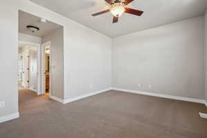 Carpeted spare room with ceiling fan