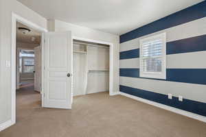 Unfurnished bedroom featuring a closet and light carpet