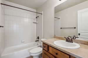 Full bathroom featuring toilet, bathtub / shower combination, and vanity