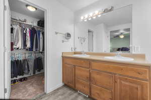 Primary bathroom with double vanity and attached walk-in closet