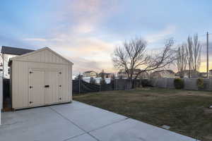 Yard at dusk featuring a storage shed