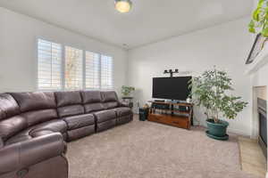 Family room with light carpet and a tiled fireplace