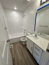 Full bathroom featuring shower / bathtub combination, vanity, visible vents, and toilet