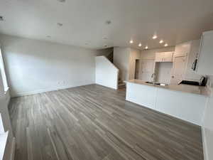Kitchen with stainless steel microwave, range, recessed lighting, a sink, and wood finished floors