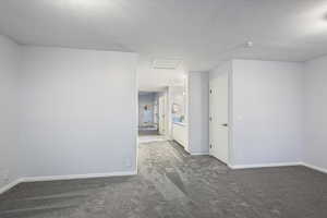 Carpeted spare room featuring a textured ceiling