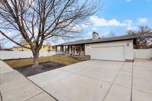 Ranch-style house featuring a front lawn and a garage