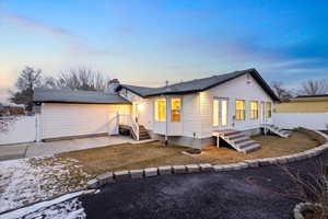 Snow covered house featuring a yard