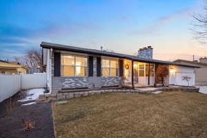 Single story home featuring a yard and a garage