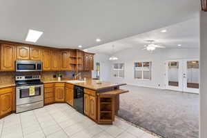 Kitchen with hanging light fixtures, kitchen peninsula, vaulted ceiling, and stainless steel appliances