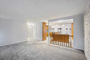 Unfurnished living room featuring light carpet and ceiling fan