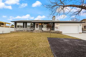 Ranch-style home featuring a front lawn and a garage