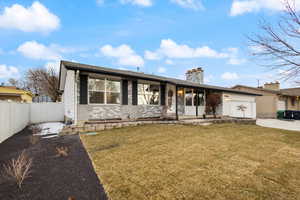 View of front of home with a garage and a front yard