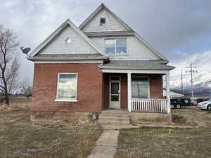 View of front of house with a front yard and a porch