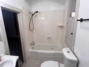 Bathroom featuring toilet and shower / bathtub combination