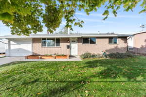 View of front of property with a front yard and a garage