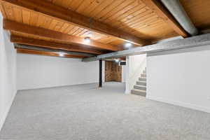 Basement featuring wood ceiling and carpet flooring