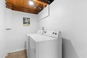 Washroom featuring washer and clothes dryer and wood ceiling