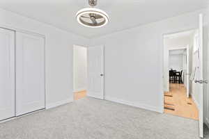 Unfurnished bedroom with light colored carpet and a closet