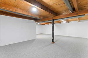 Basement with carpet floors and wooden ceiling