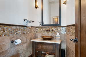 Bathroom featuring tile walls and vanity