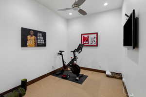 Exercise room featuring ceiling fan and carpet