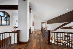 Corridor featuring dark wood-type flooring, an inviting chandelier, and lofted ceiling with beams