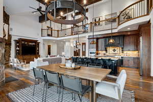 Dining space with ceiling fan, dark hardwood / wood-style floors, and a high ceiling