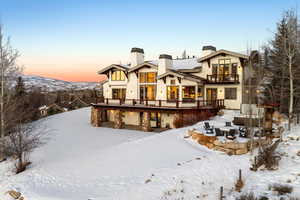 Snow covered property featuring a mountain view and a balcony