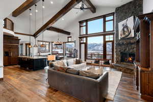 Living room with a mountain view, hardwood / wood-style floors, a fireplace, high vaulted ceiling, and sink