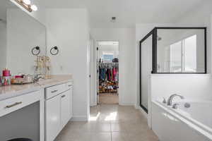 Bathroom featuring tile patterned flooring, plus walk in shower, and vanity