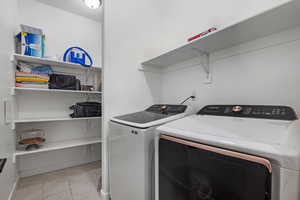 Laundry room featuring light tile patterned floors and washer and dryer