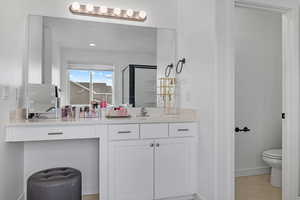 Bathroom with vanity, tile patterned floors, toilet, and walk in shower