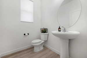 Bathroom with sink, wood-type flooring, and toilet