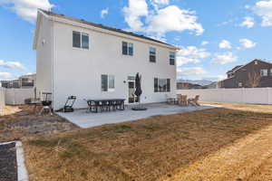 Back of property with a yard and a patio