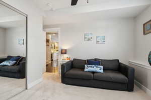 Carpeted living room featuring ceiling fan