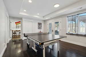 Playroom featuring french doors, a tray ceiling, and dark hardwood / wood-style flooring