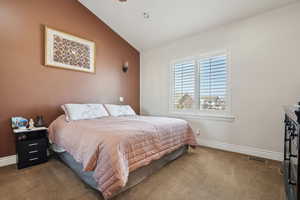 Carpeted bedroom with lofted ceiling