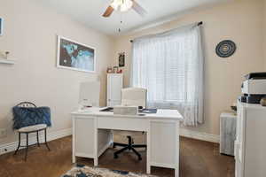 Home office with ceiling fan and dark carpet