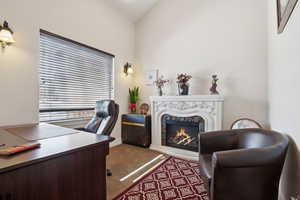 Office area featuring vaulted ceiling and a high end fireplace