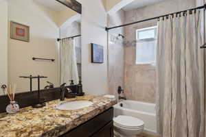 Full bathroom with vanity, toilet, and shower / bath combo with shower curtain