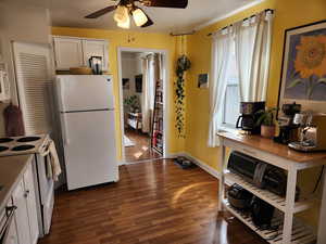 Kitchen featuring ceiling fan, white appliances, white cabinets, and dark hardwood / wood-style flooring