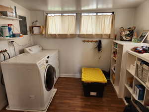 Laundry room featuring washer and clothes dryer, dark wood-type flooring, and electric panel