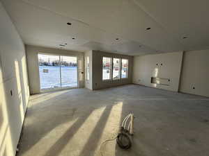 Unfurnished living room with a water view and concrete flooring