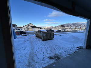 Yard layered in snow featuring a mountain view