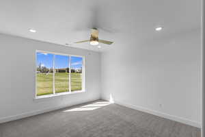 Carpeted empty room featuring baseboards, visible vents, recessed lighting, and ceiling fan