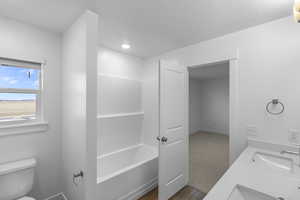 Primary bathroom featuring toilet, sink, and hardwood / wood-style floors