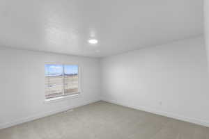 Primary bedroom with light colored carpet