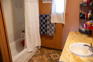 Bathroom with tile patterned flooring, shower / bath combo, and vanity