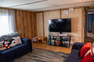 Living room with wood-type flooring and wood walls