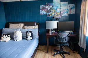 Bedroom with wood walls and wood-type flooring